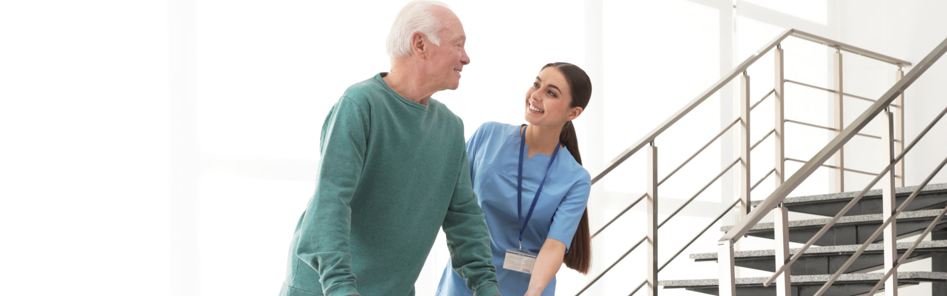 female caregiver assisting an elderly man walking