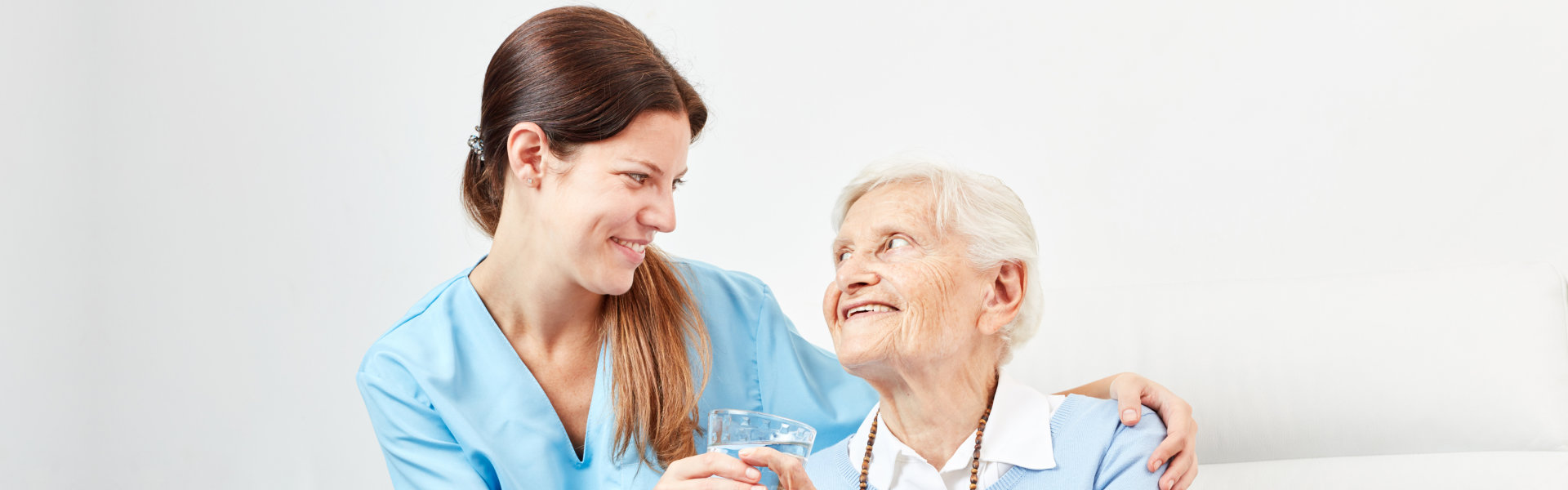 female caregiver smiling at an elderly woman