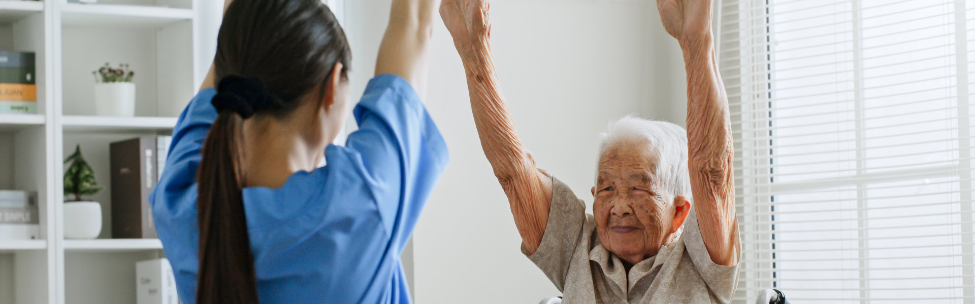 Nurse and the elder woman in a wheel chair doing some activities