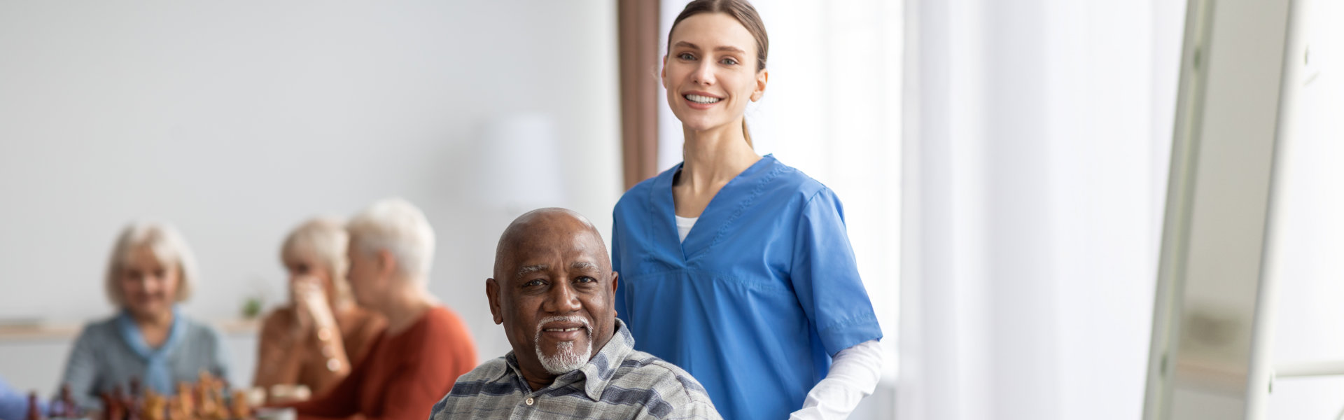 female caregiver with elderly man smiling