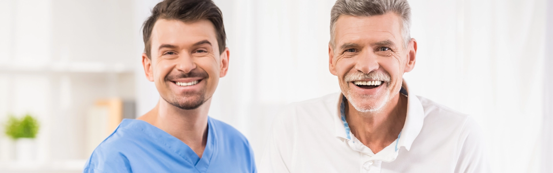 male caregiver with elderly man smiling