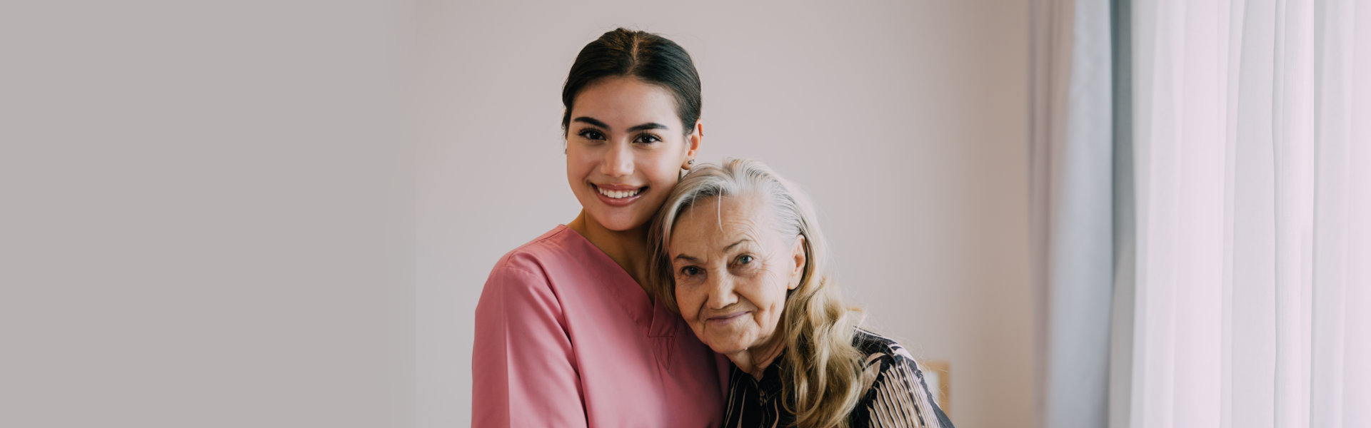 female caregiver with elderly woman smiling