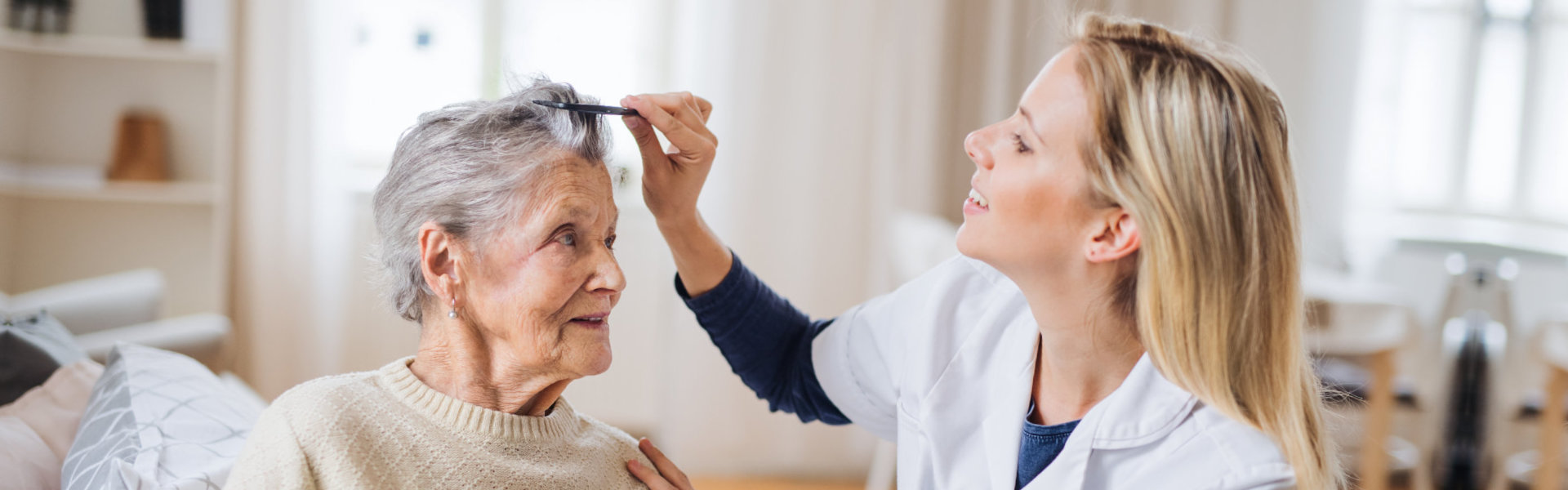 Female home care worker comb the hair of the senior woman